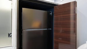 A modern kitchen with a stainless steel refrigerator, a wooden cabinet, and a white countertop. - LaVie Yotsuya (Tokyo)