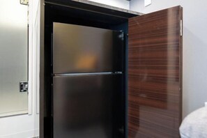 A modern kitchen with a stainless steel refrigerator, a wooden cabinet, and a white countertop. - LaVie Yotsuya (Tokyo)
