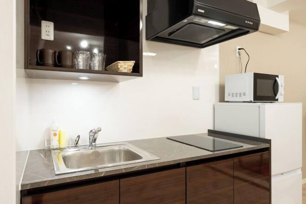 A kitchen with a sink, microwave, and cabinets.