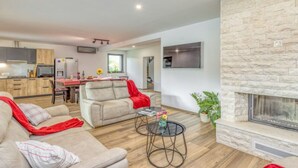 Uma sala de estar moderna com lareira, área de jantar e cozinha.