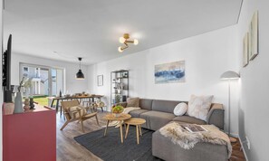 Un salon moderne comprenant un canapé, une table basse et un coin repas avec des chaises et une table.