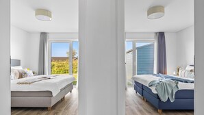 A bedroom with a bed, a window, and a view of the outdoors.