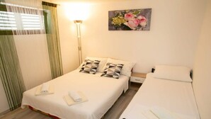 Une chambre d’hôtel avec deux lits, une table de chevet, une lampe et un tableau au mur.