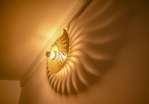 A wall-mounted light fixture with a leaf design.