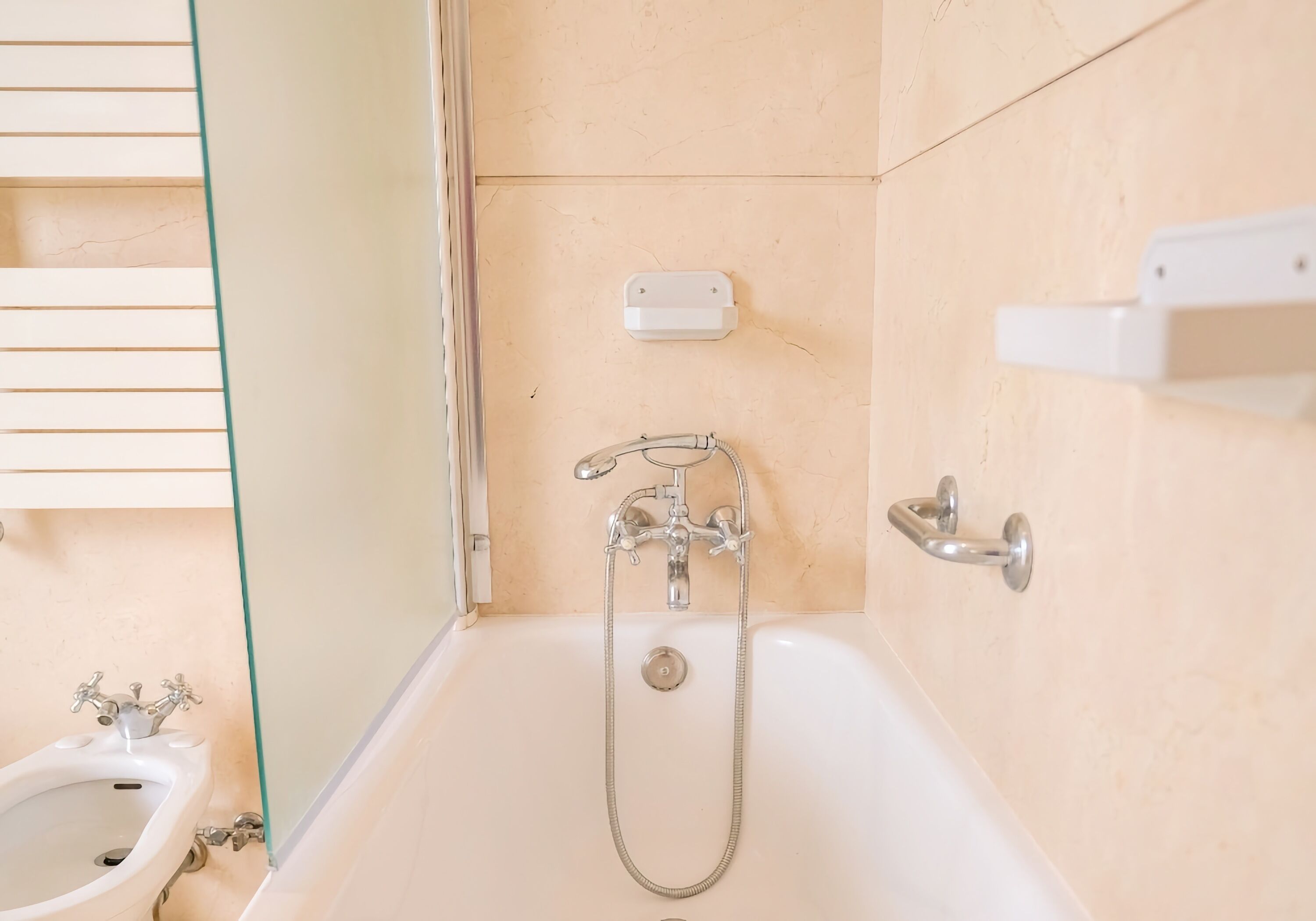 A bathroom with a bathtub, a shower, and a bidet.