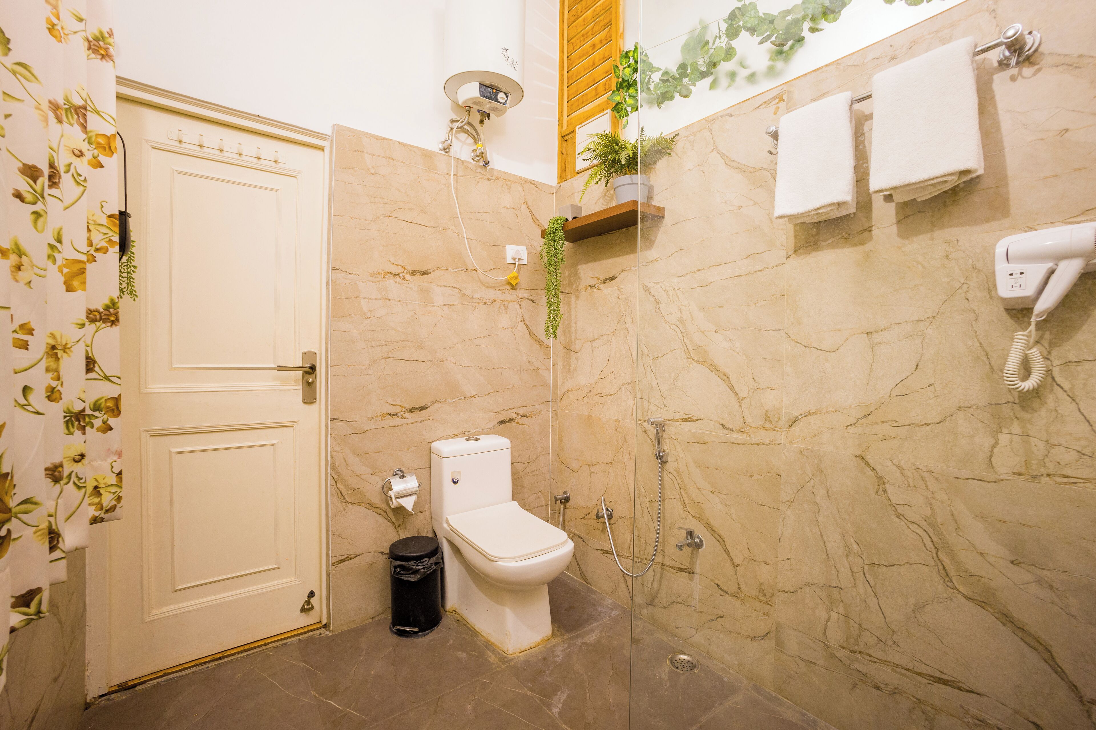 A bathroom with a toilet, shower, and a towel rack.