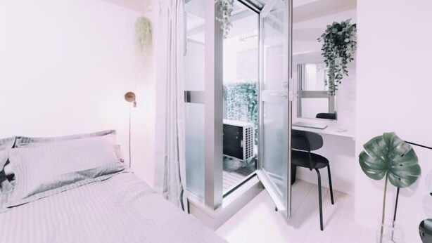 A bedroom with a bed, a desk, and a chair. - Minimalist Loft 5: Namba Compact Studio & 24/7 Gym (Osaka)