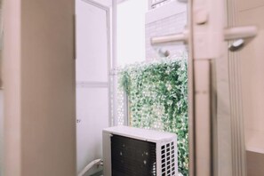 A room with a white door, a white radiator, and a white air conditioning unit. - Minimalist Loft 5: Namba Compact Studio & 24/7 Gym (Osaka)