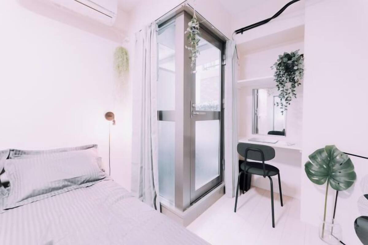 Un dormitorio moderno con cama, escritorio y silla.