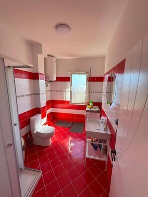 ดีลักซ์อพาร์ทเมนท์, ระเบียง, วิวเมือง | ห้องน้ำ | รองเท้าสวมภายในห้อง