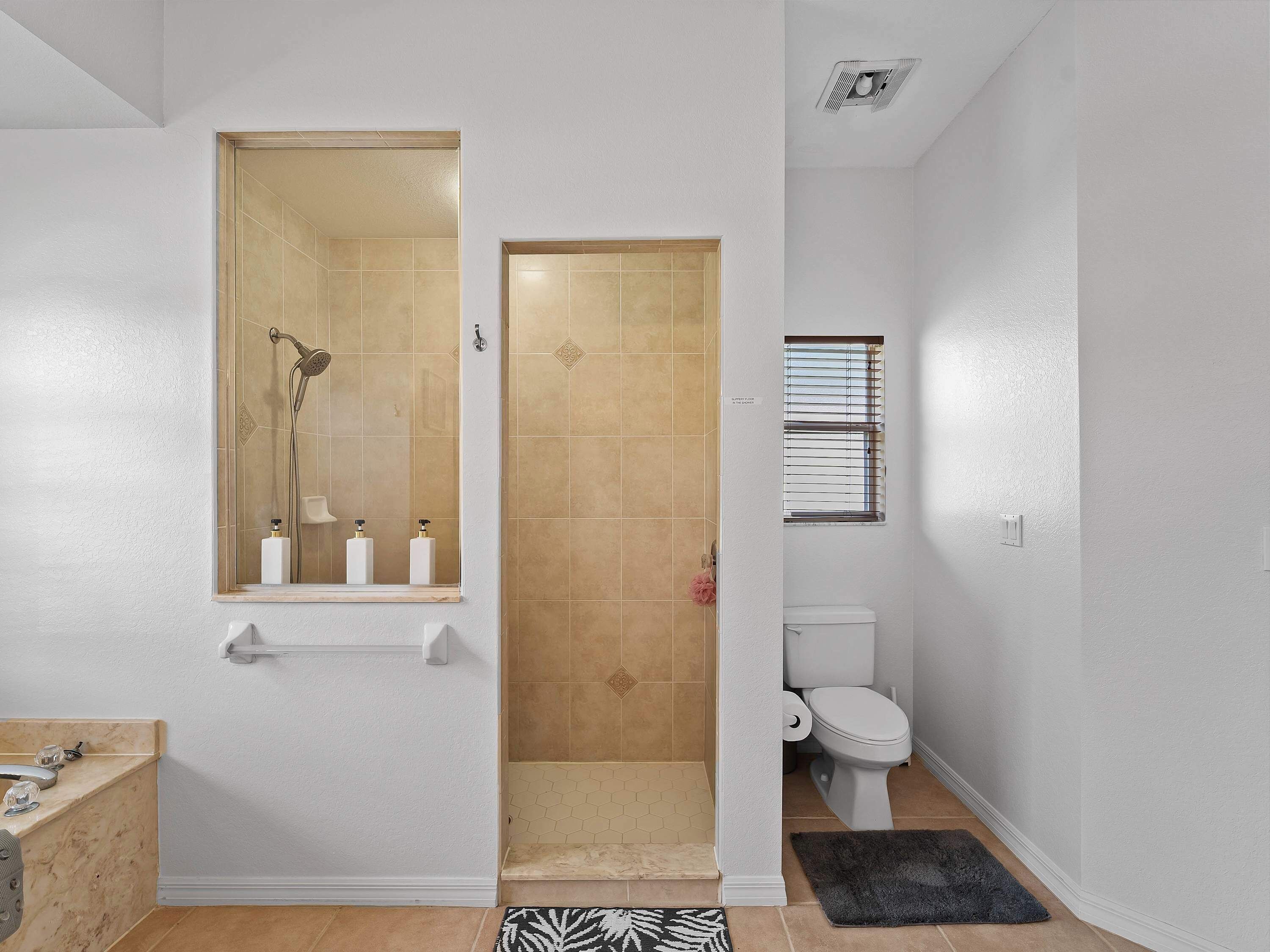 Une salle de bain avec douche, toilettes et lavabo.