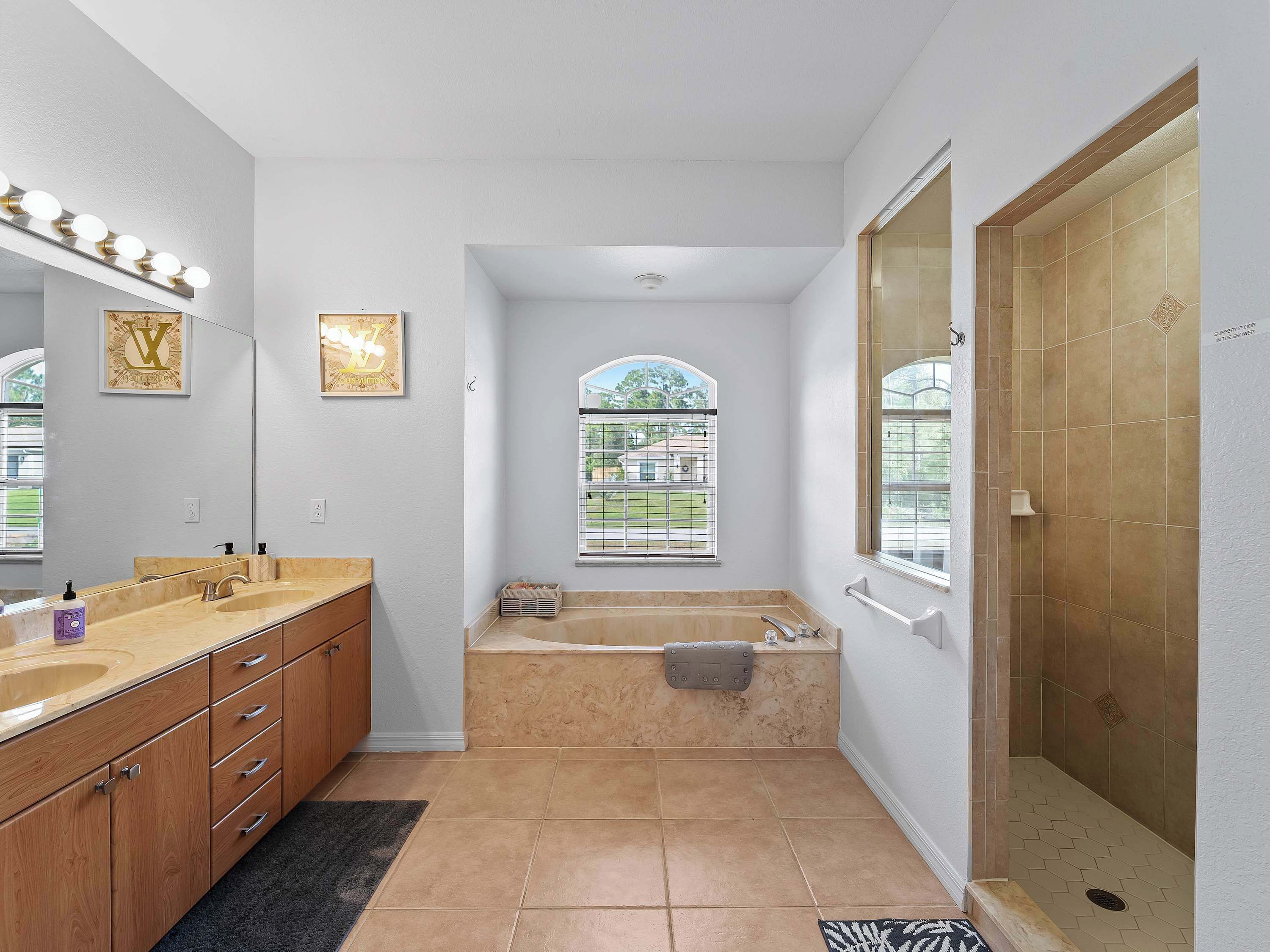 Ein Badezimmer mit Waschtisch, Badewanne, Dusche und einem Fenster mit Blick.