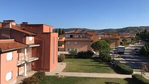 Zona residencial con edificios de varios pisos, un camino pavimentado y cielo despejado.