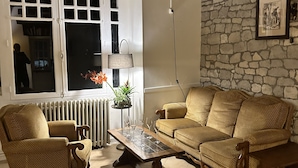 Una sala de estar con pared de piedra, un sofá, una mesa de centro y una ventana con vistas.