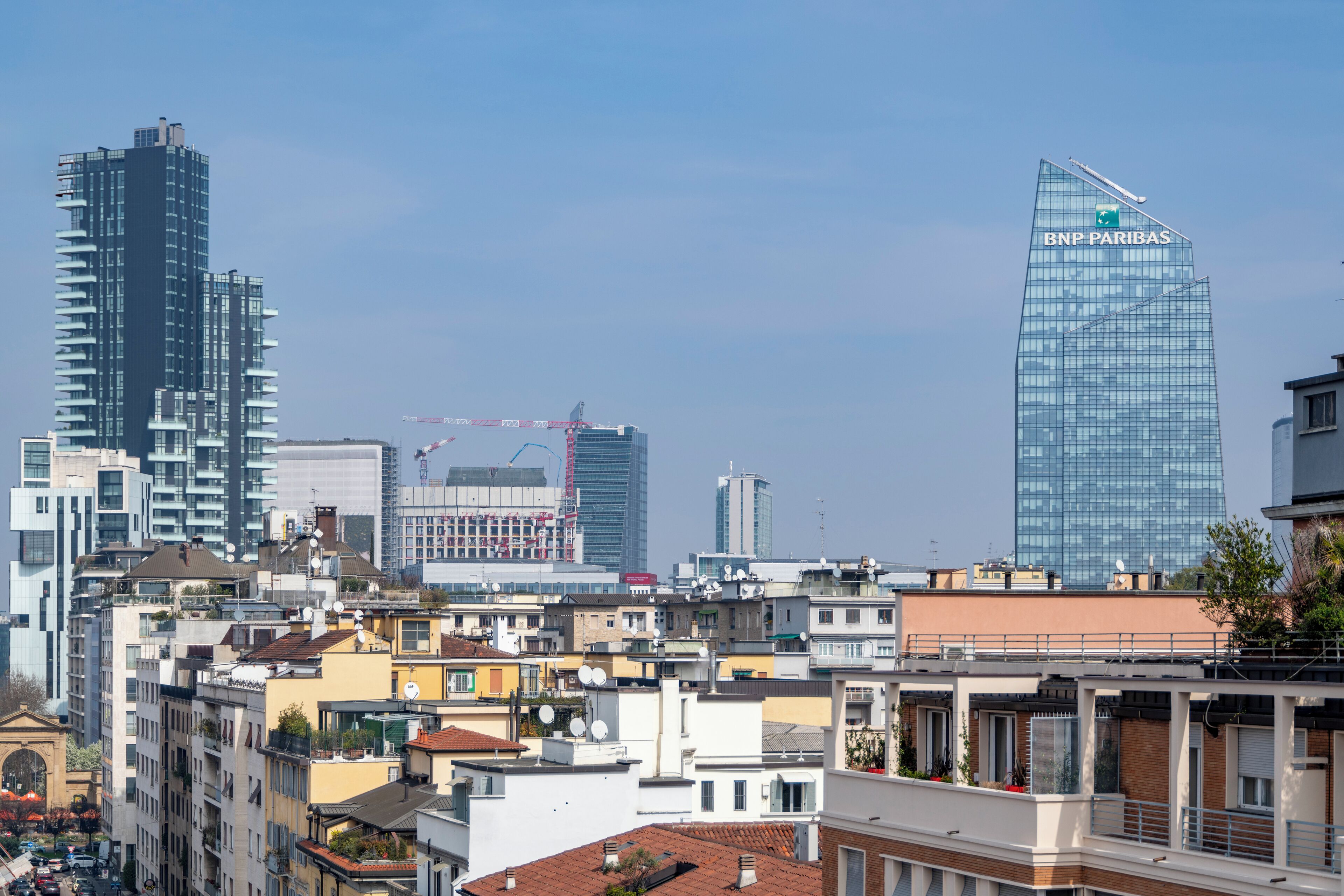 Un paisaje urbano con una mezcla de edificios modernos y tradicionales, incluyendo un destacado rascacielos de BNB Paribas.