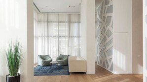 A modern living room with a sofa, a coffee table, and a potted plant. - Luxury Apt Tower | Sea View Bat Yam | Mamad (Bat Yam)