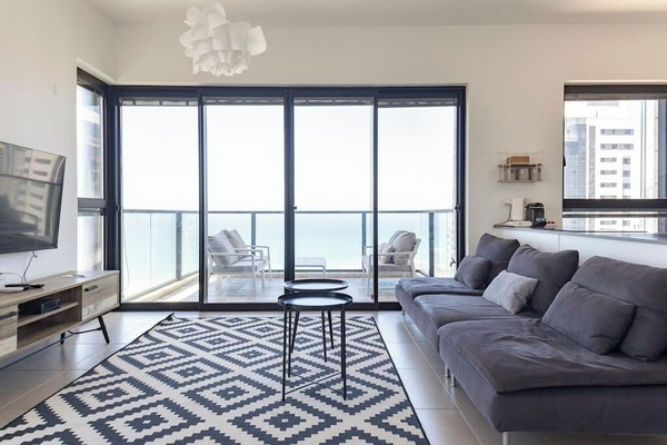 Bright living room opens to balcony views, creating an inviting space to relax after beach walks.
