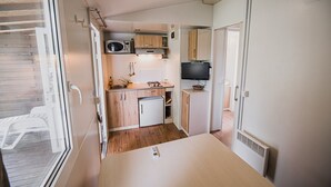 A compact kitchenette with a microwave, sink, and small refrigerator.