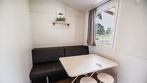 A compact room with a sofa, a small table, and two stools.