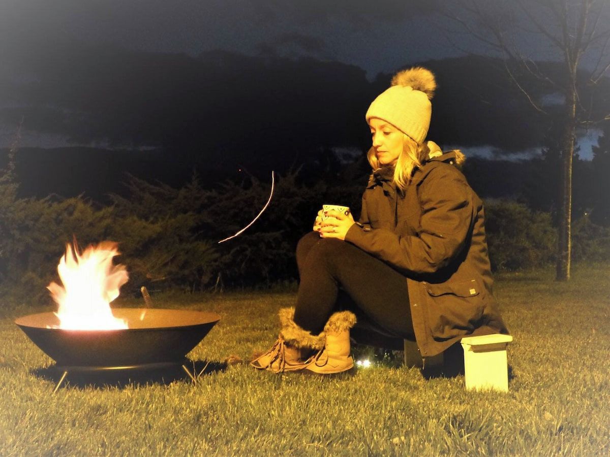 A person sitting by a campfire at night.