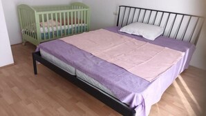 A single bed with a headboard, a green crib, and a white pillow. - Spacious & Cozy Apartments Dugi Rat (Dugi Rat)