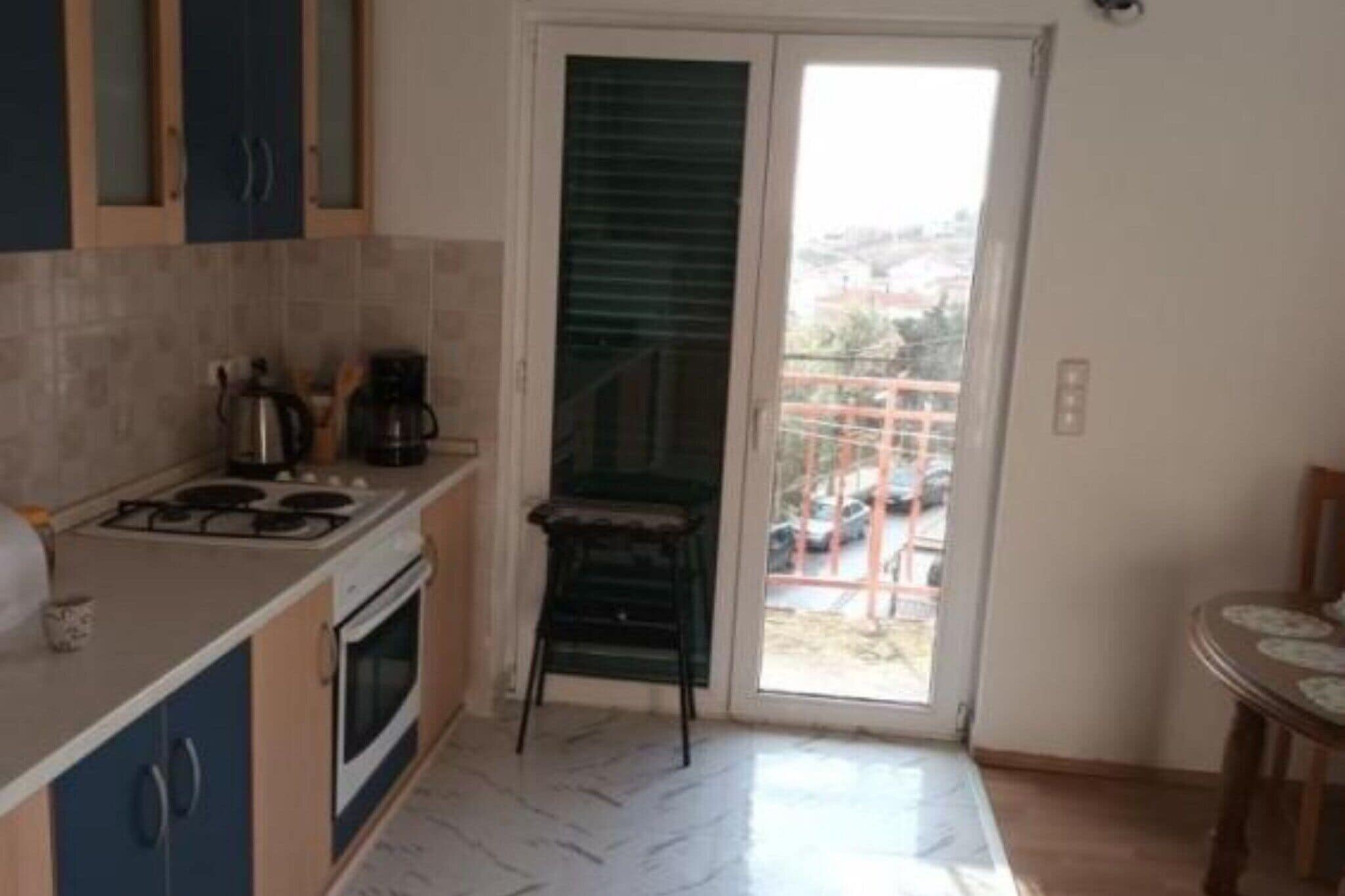 Cocina compacta con estufa a gas, horno y una pequeña mesa de comedor.