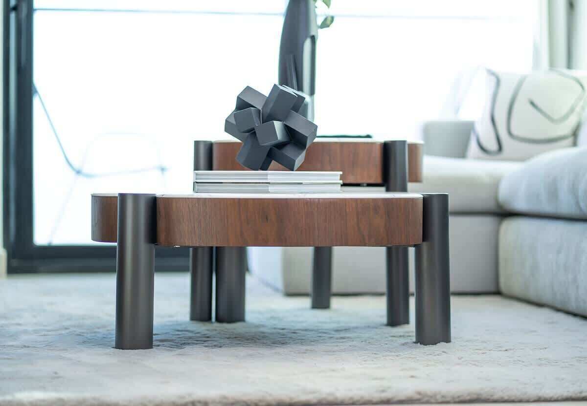 Een moderne woonkamer met een houten salontafel, een decoratief beeld en een bank.