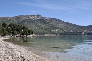 A clear view of a lake with a rocky shoreline and a mountain in the background. - Apartment Jakić - One Bedroom Apartment with Garden View (Orebic)