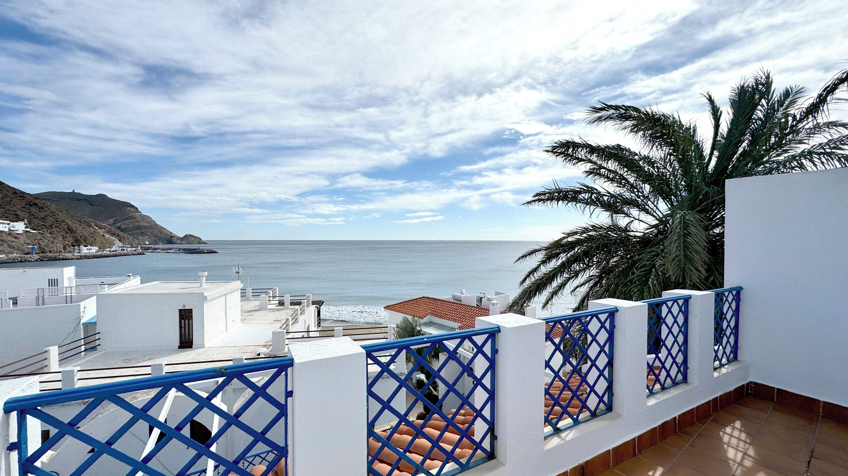 Un balcón costero con vista al mar y a la montaña.