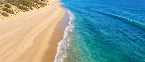 Una platja amb aigua cristal·lina i sorra daurada.
