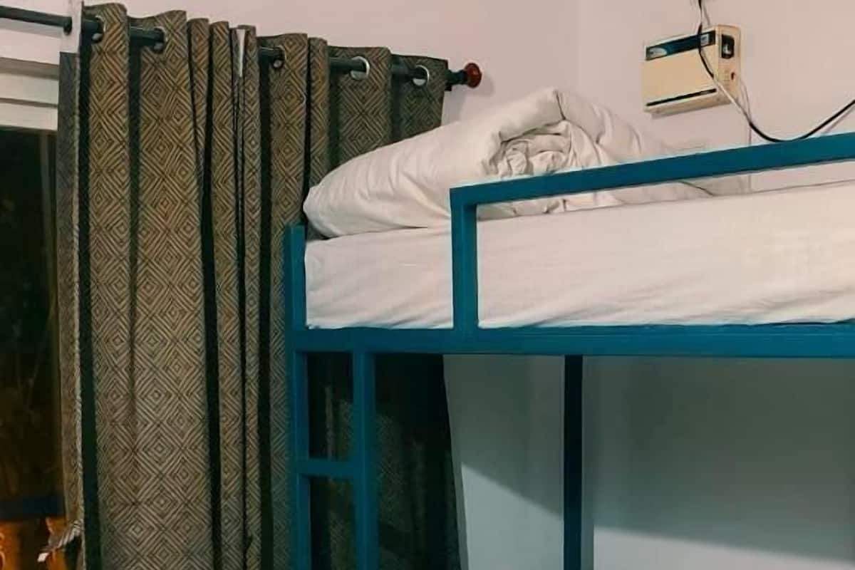 A bunk bed room with patterned curtains and a tiled floor.