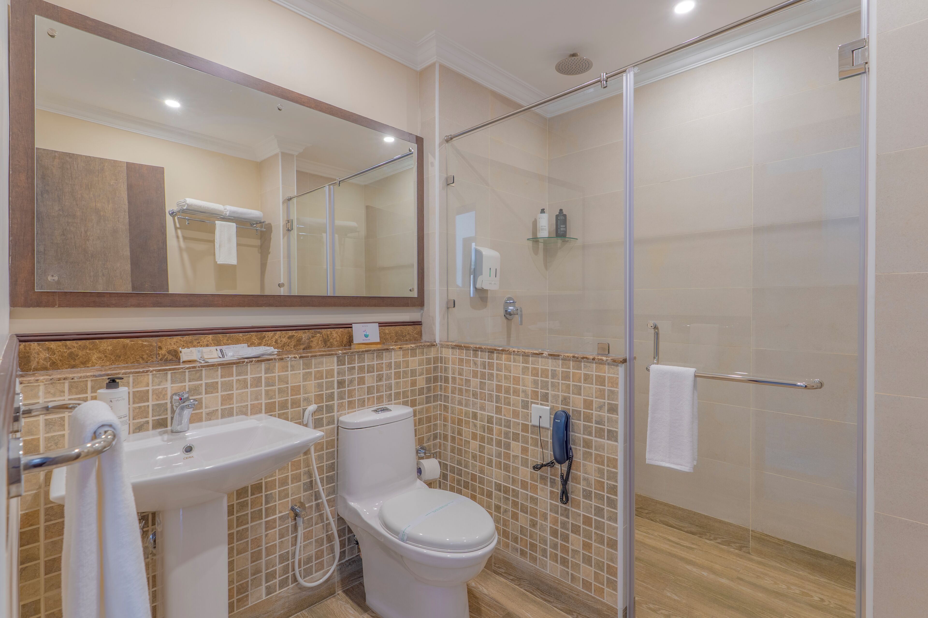 Une salle de bain équipée d’un lavabo, de toilettes et d’une douche à parois en verre.