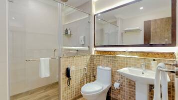 A modern bathroom with a glass-enclosed shower, a toilet, and a sink.