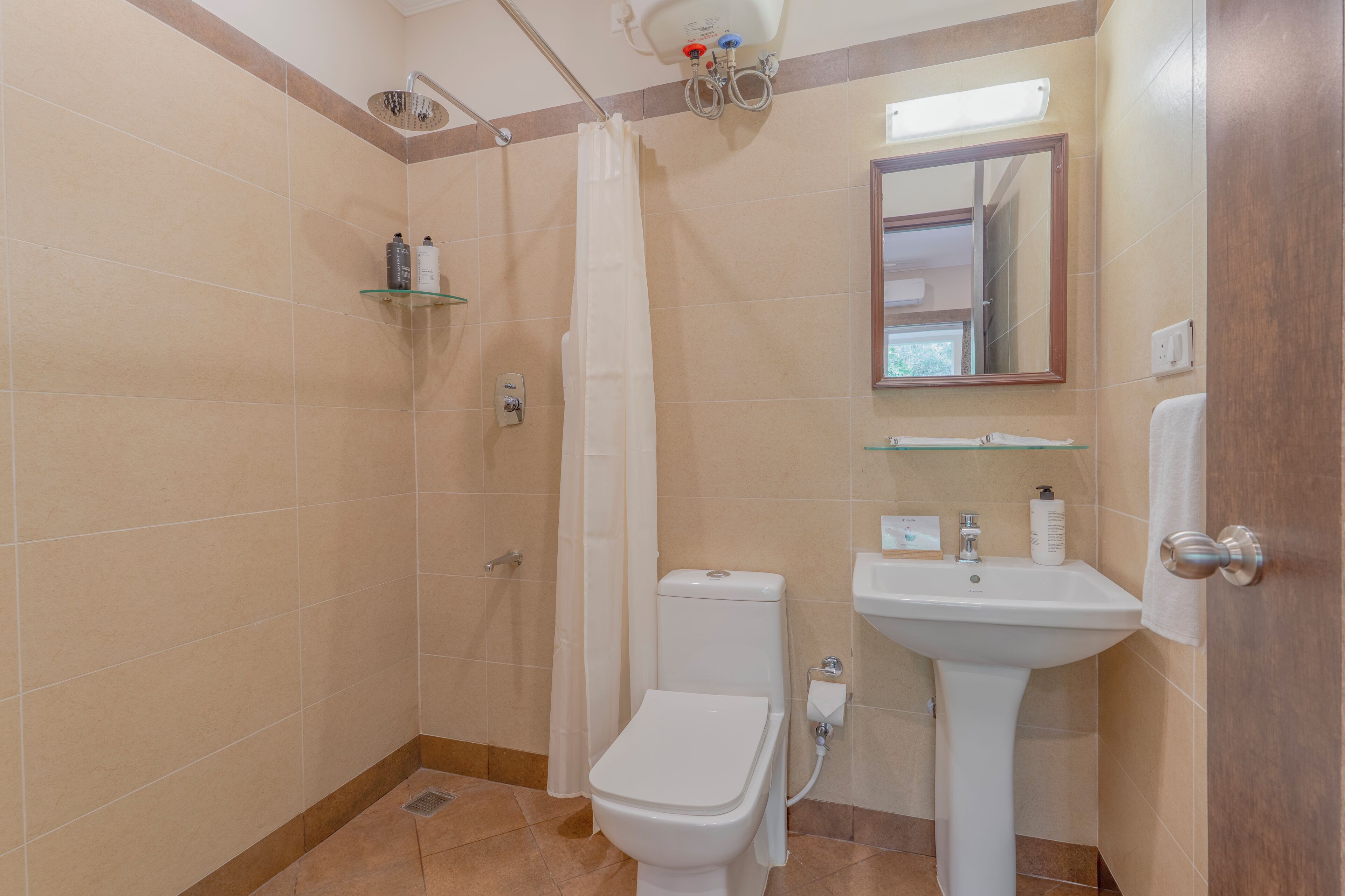 Un baño con ducha, inodoro, lavabo y espejo.