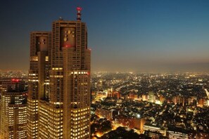 Un edificio alto con varios pisos, ventanas grandes y una antena destacada en la parte superior.