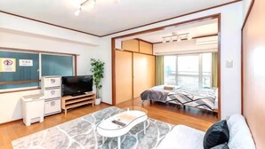 A modern hotel room with a bed, a TV, a desk, and a plant. - Yotsuya Matsumoto Hotel (Tokyo)
