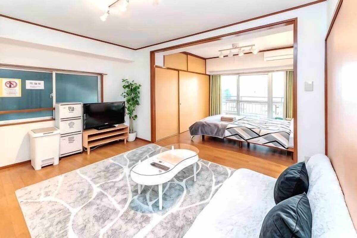 Una habitación de hotel moderna con cama, televisión, escritorio y una planta.