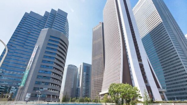 A cityscape with modern high-rise buildings, including a prominent curved structure and a tall skyscraper with a unique facade. - Yotsuya Matsumoto Hotel (Tokyo)