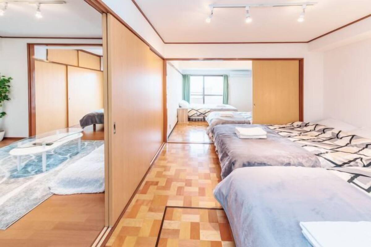 Una habitación de hotel moderna con una cama grande, un área de estar separada y vistas a la ciudad.