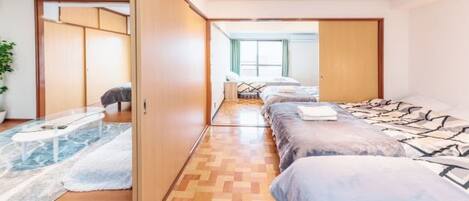 A modern hotel room with a large bed, a separate seating area, and a view of the city.