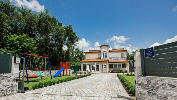 A residential building with a paved driveway, a swing set, and a slide in the yard. - Countryside Villa Tajo - Four Bedroom Holiday Home  with Swimming Pool (Imotski)