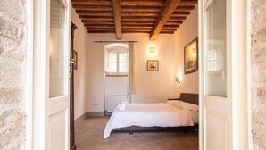 Une chambre à coucher avec un lit, une fenêtre et une porte.
