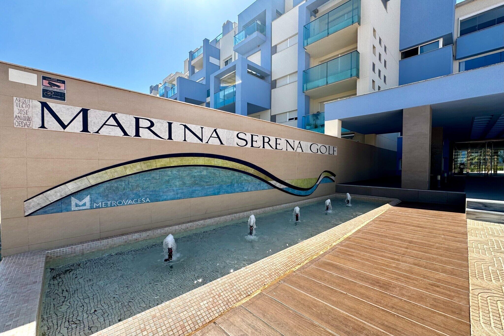 Een modern gebouw met een bord waarop 'MARINA SERENA GOLF' staat.