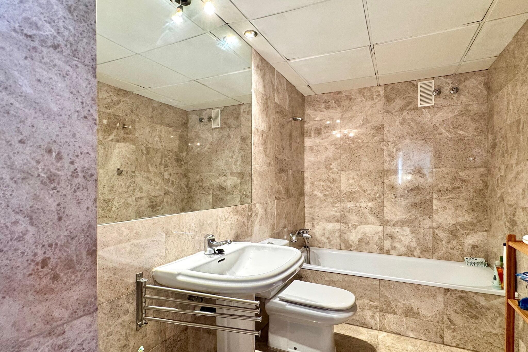 Un baño con lavamanos, inodoro y bañera.