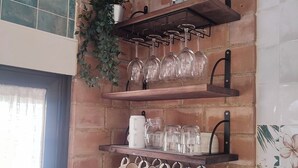 Eine Küche mit Backsteinwand, einer Kaffeemaschine, einem Becherhalter und einem Besteckbehälter.