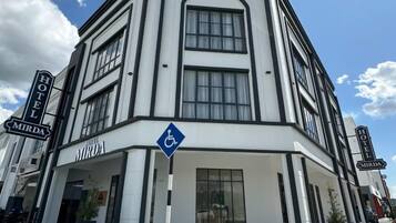 A corner building with a sign for 'Hotel Mirada' and a blue handicap accessibility sign.