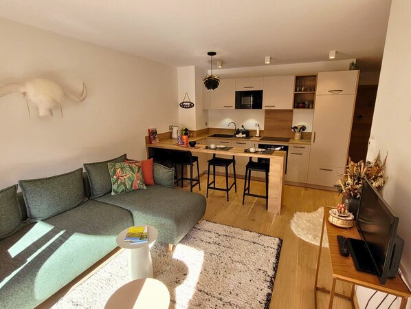 Un salon moderne avec un canapé, une table basse et un meuble pour la télévision.