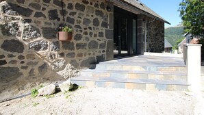 Un bâtiment en pierre doté d’un escalier en pierre menant à une entrée abritée.