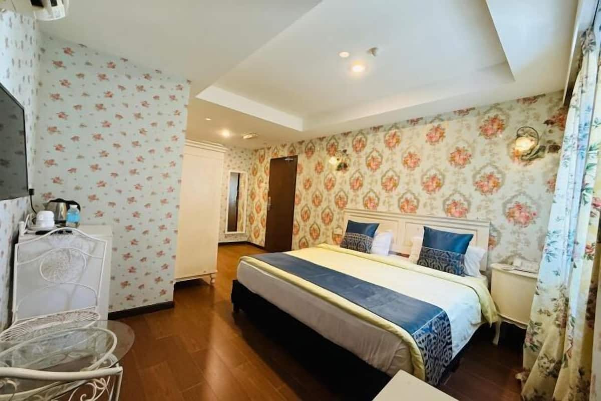 A bedroom with a bed, a bedside table, a chair, and a wardrobe.