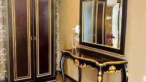 A room with a dark wooden wardrobe, a console table, and a mirror. - K Garden Hotel Sungai Petani (Sungai Petani)